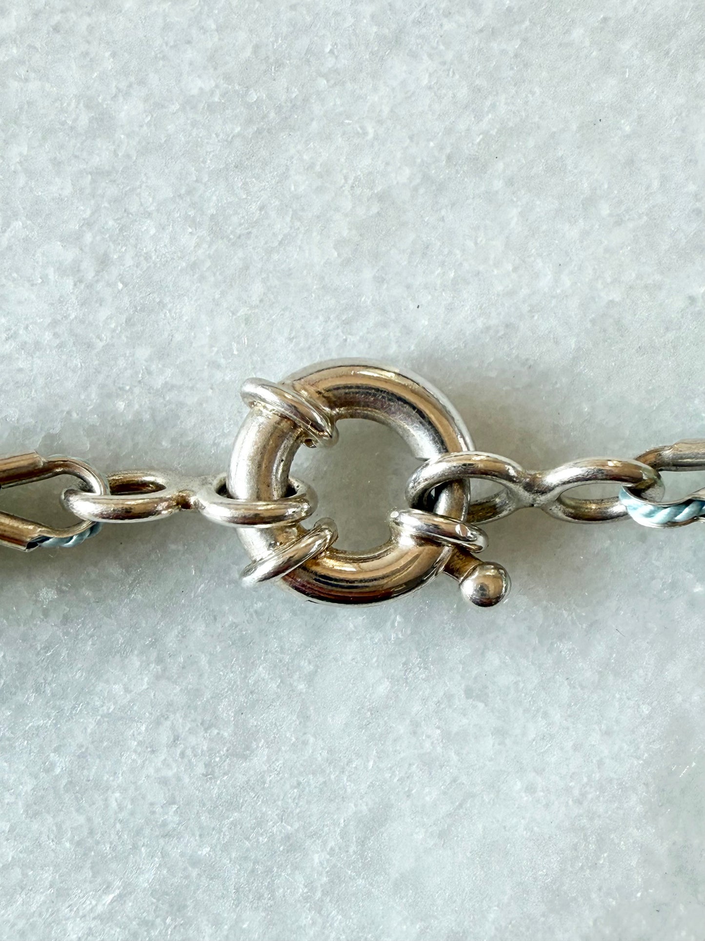 A close-up of a sterling silver sailor clasp