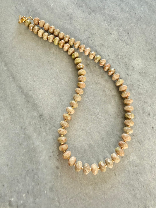 Necklace with beige beads on a gray surface