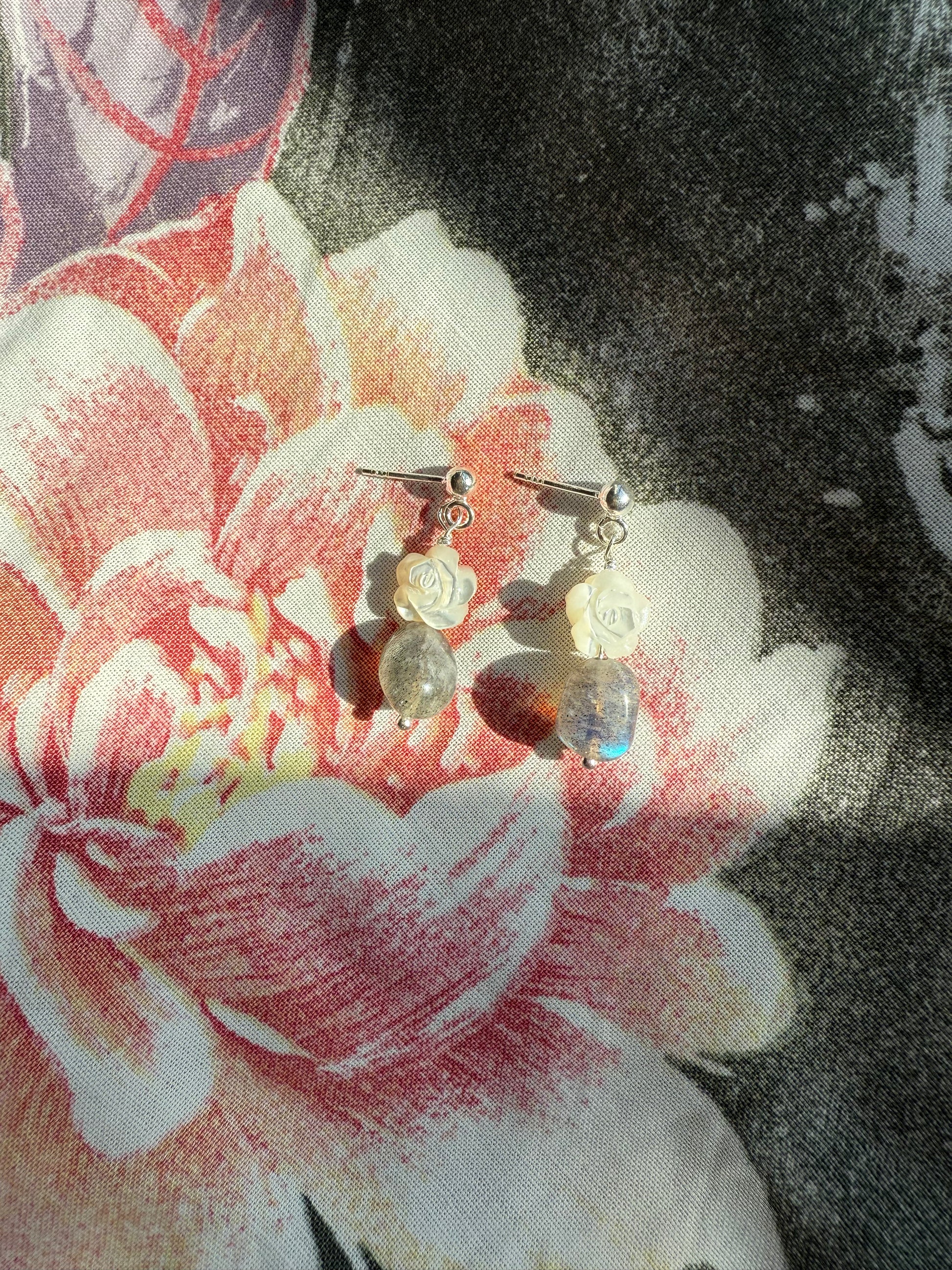 Pair of earrings on a floral fabric background
