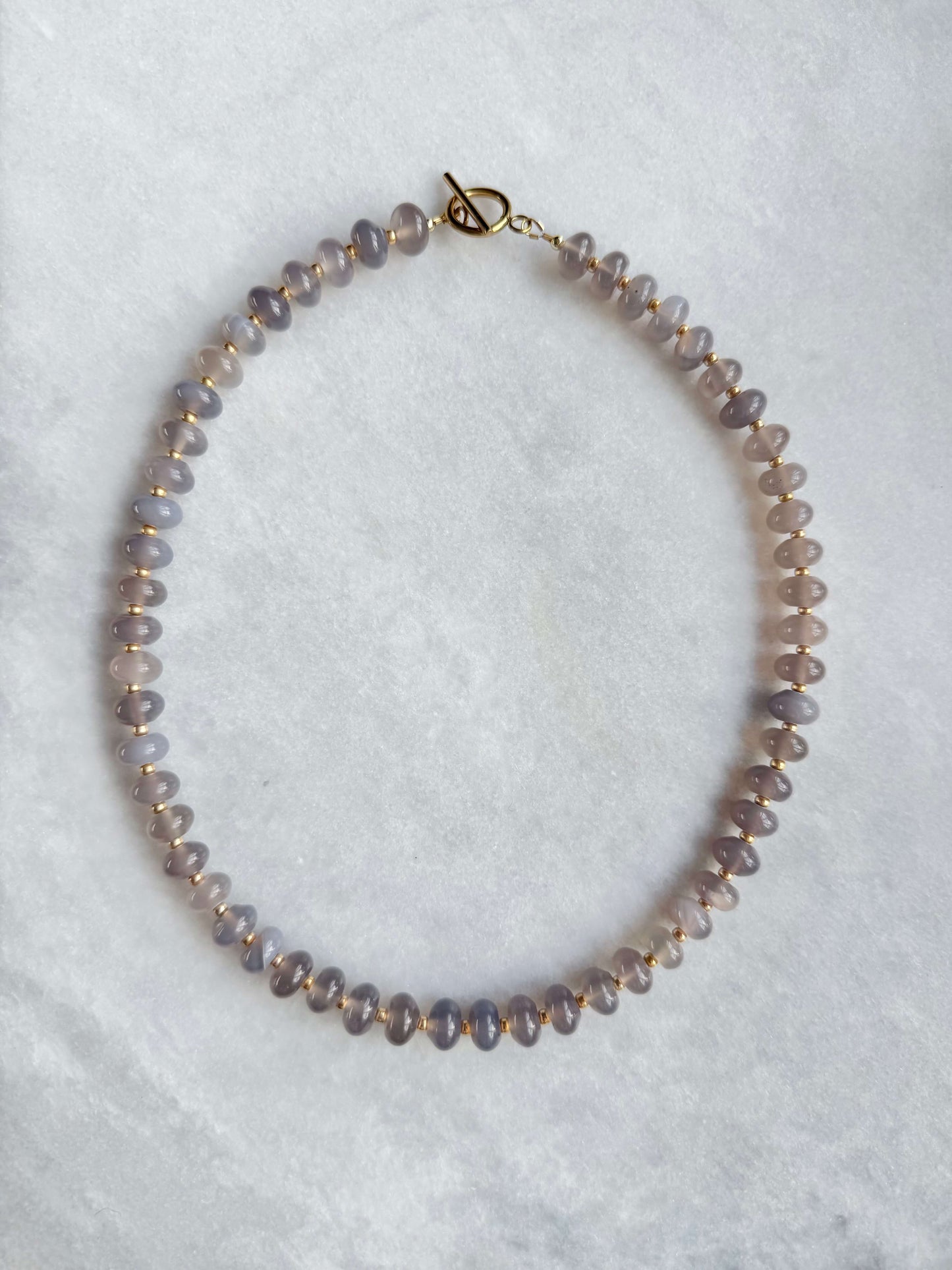 Necklace with small beads on a light gray background