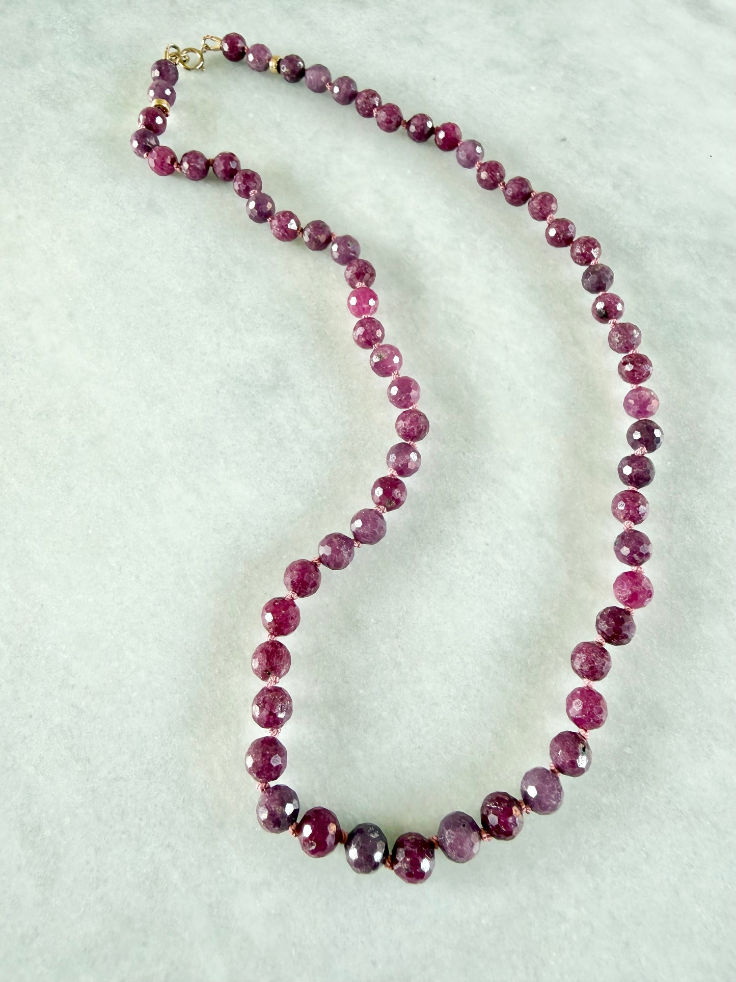 Necklace with pink beads on a light gray background