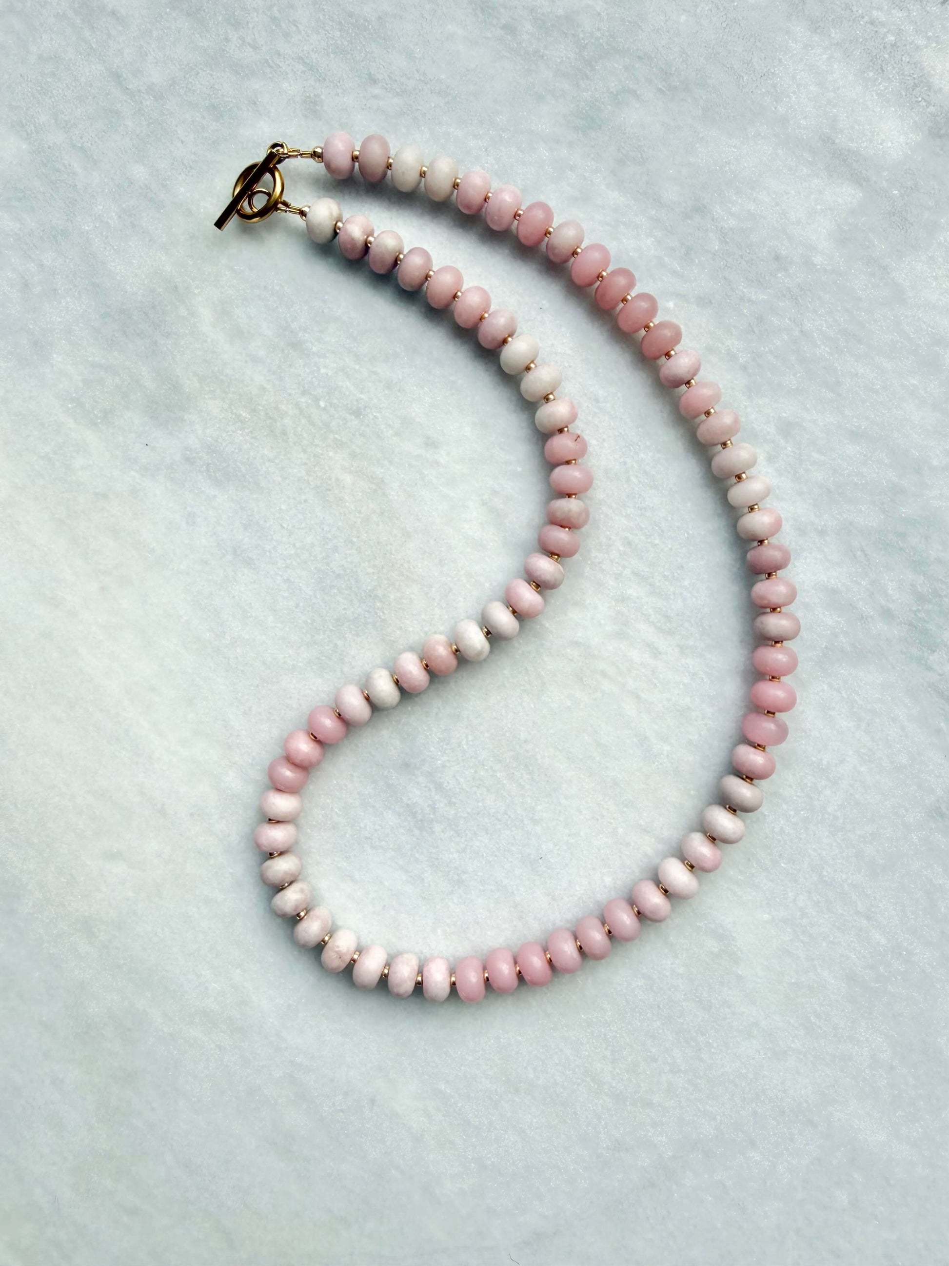 Necklace with pink beads on a light gray background