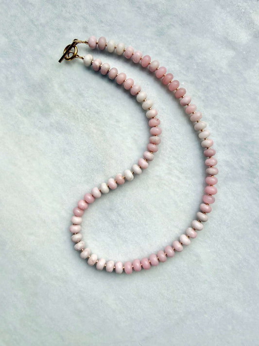 Necklace with pink beads on a light gray background