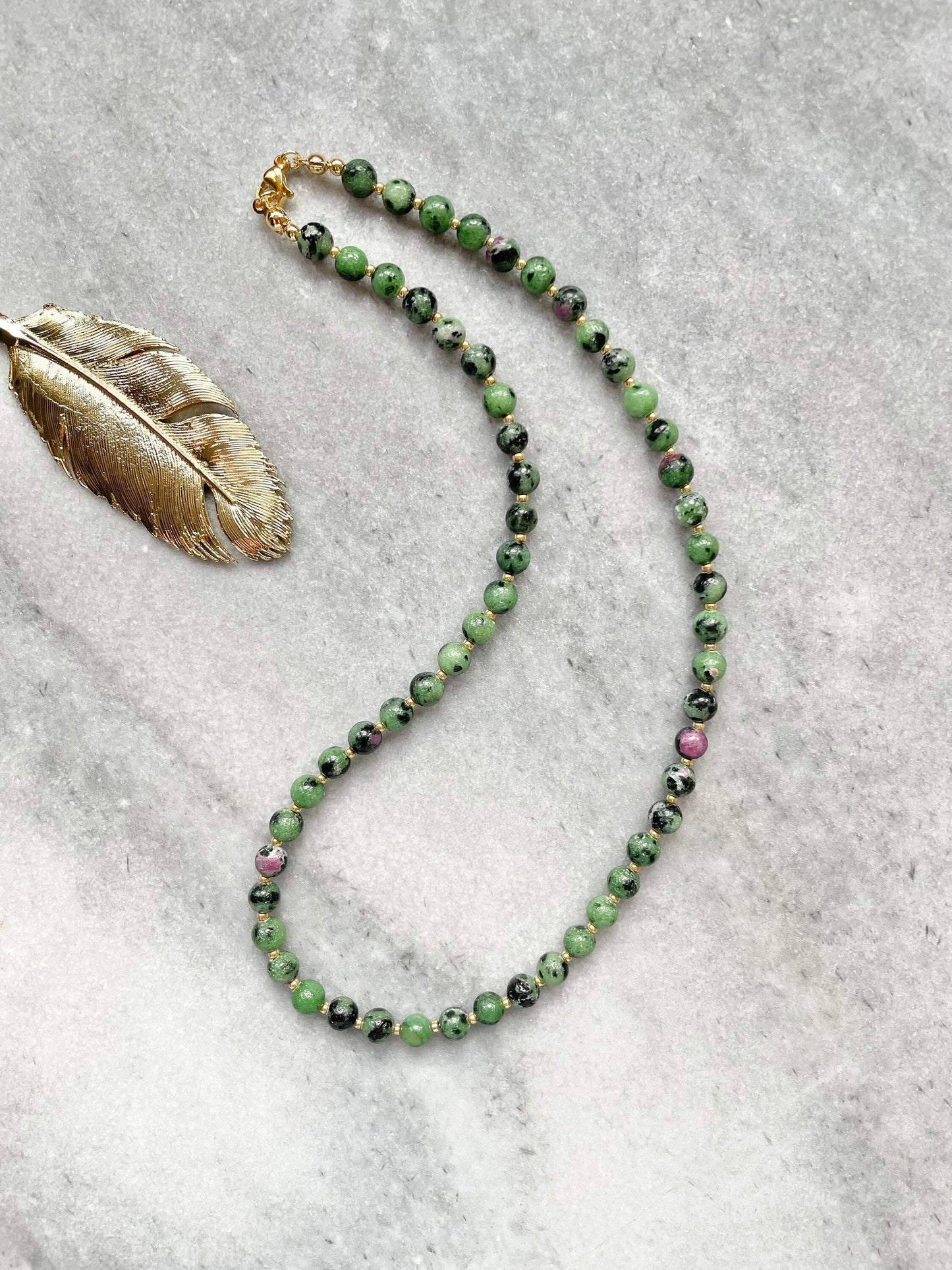 A ruby zoisite beaded necklace with gold vermeil plating and miyuki spacer beads, displayed against a neutral background.