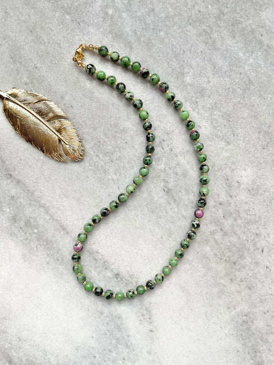 A ruby zoisite beaded necklace with gold vermeil plating and miyuki spacer beads, displayed against a neutral background.
